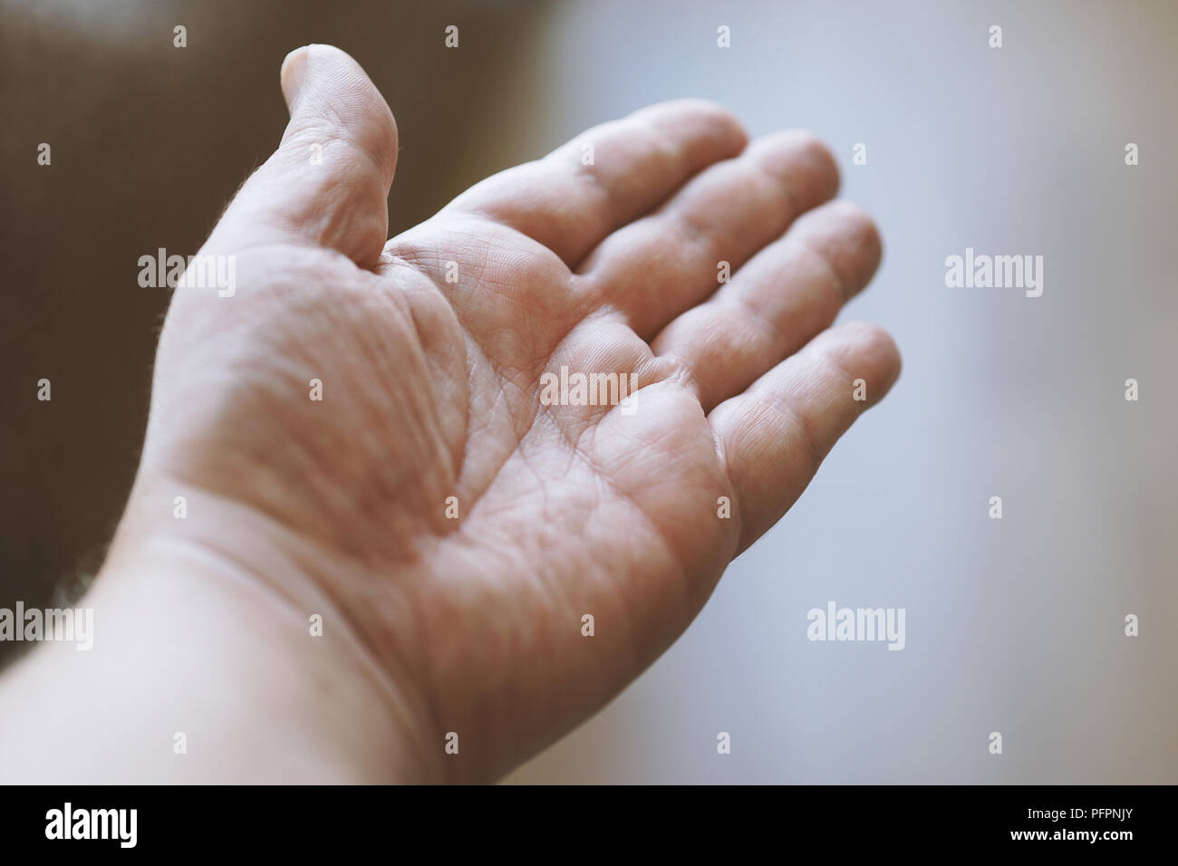 male open hand with empty palm up, personal perspective with shallow depth of field Stock Photo