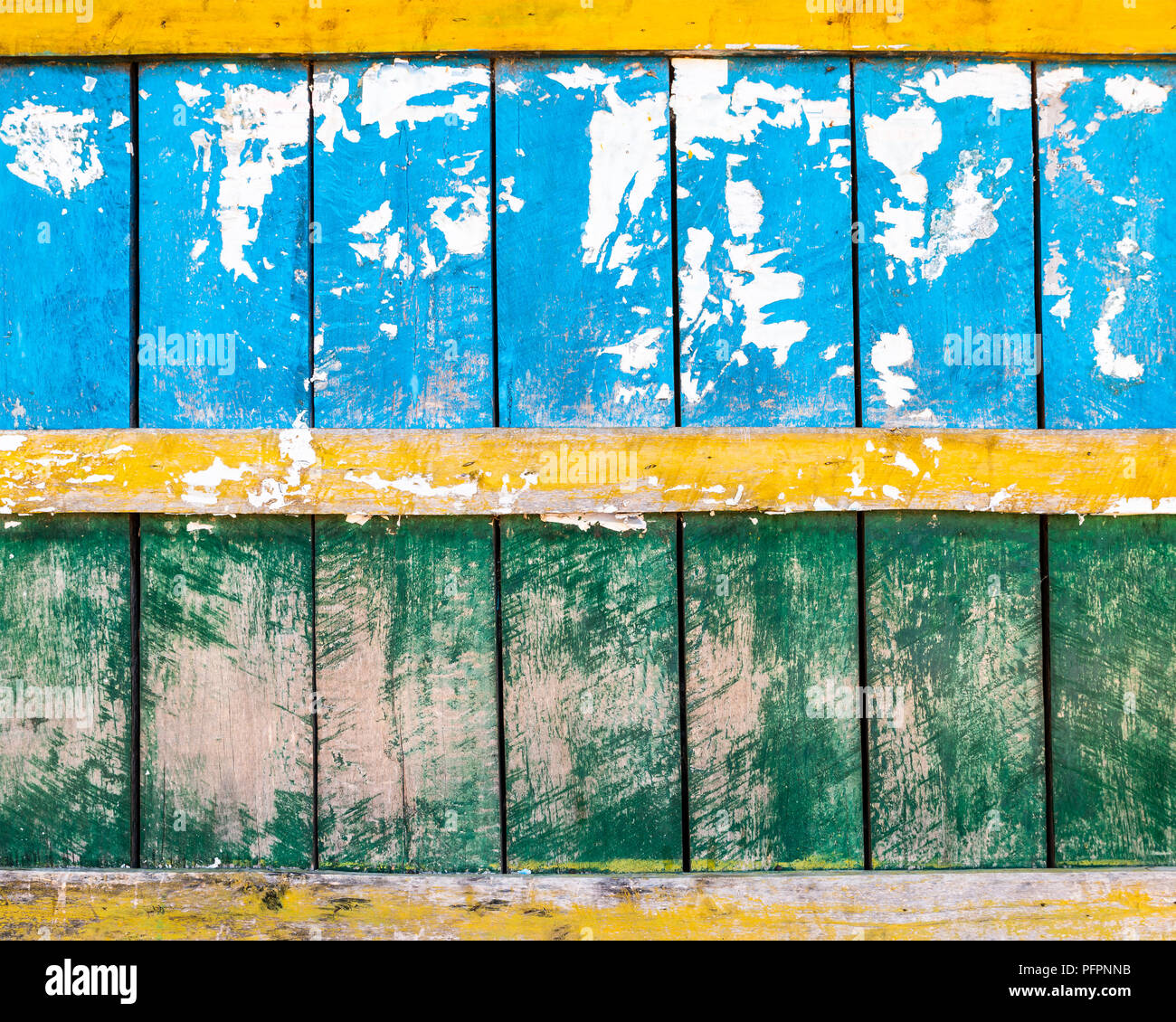 Grungy blue, green and yellow wood wall texture, torn paper in the top half Stock Photo