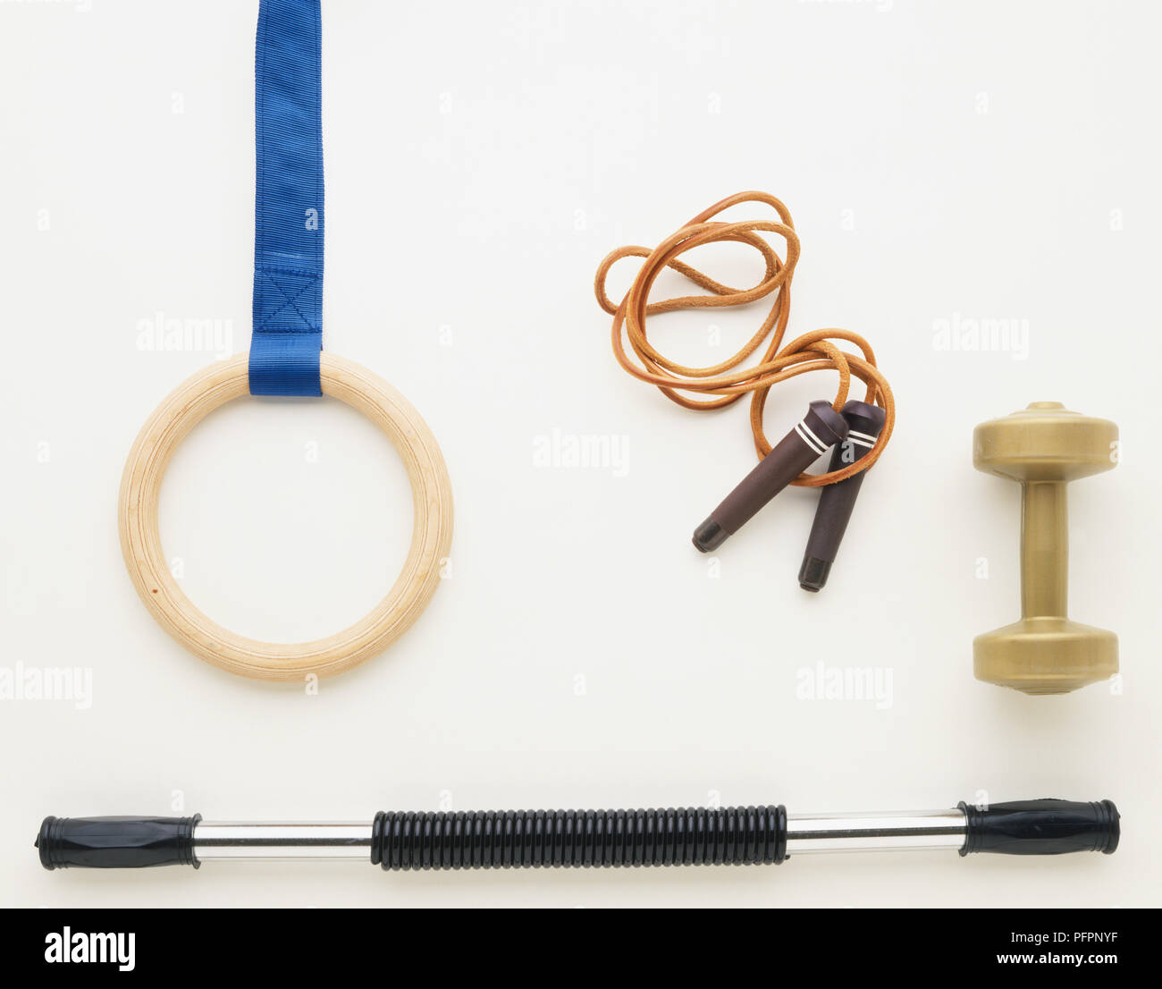 Gymnastics equipment, including wooden with blue strap, skipping rope, vinyl dumb-bell, bendy bar in straight position Stock Photo