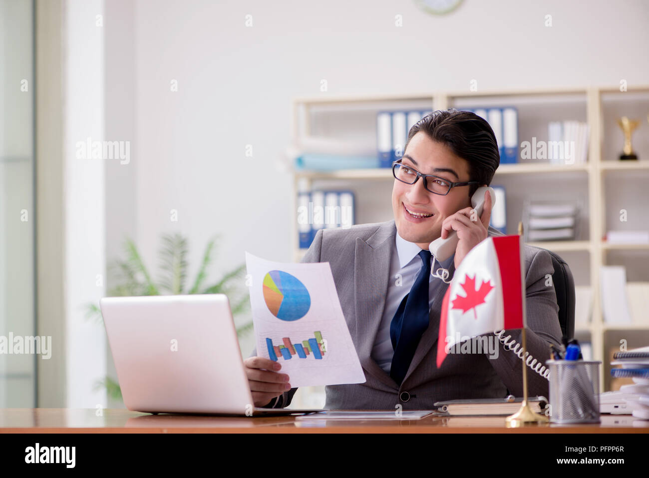 Businessman with Canadian flag in office Stock Photo - Alamy