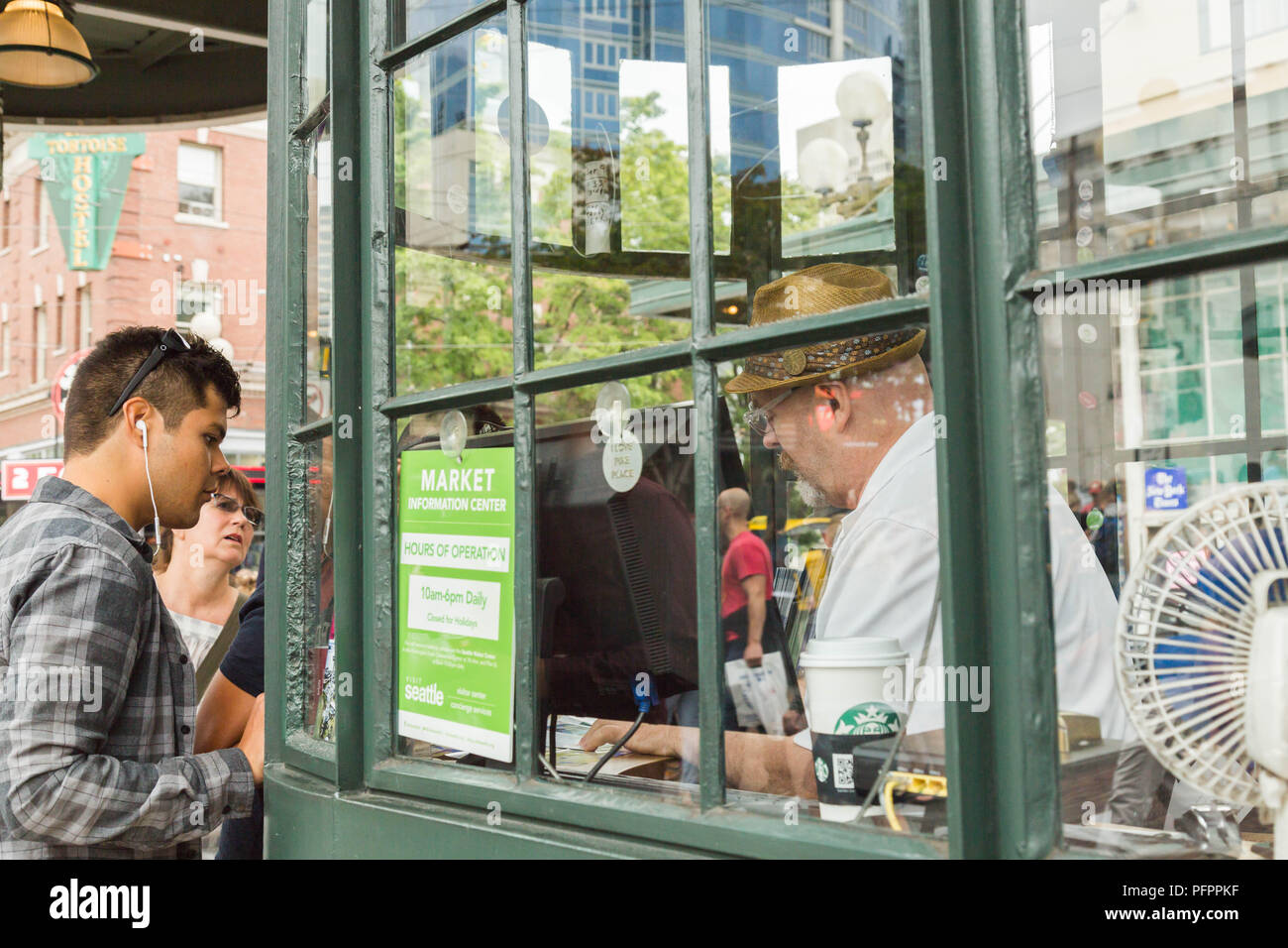 Tourists at Pike Place Market interacts with a man inside old fashioned booth, Seattle, Washington, USA. Stock Photo
