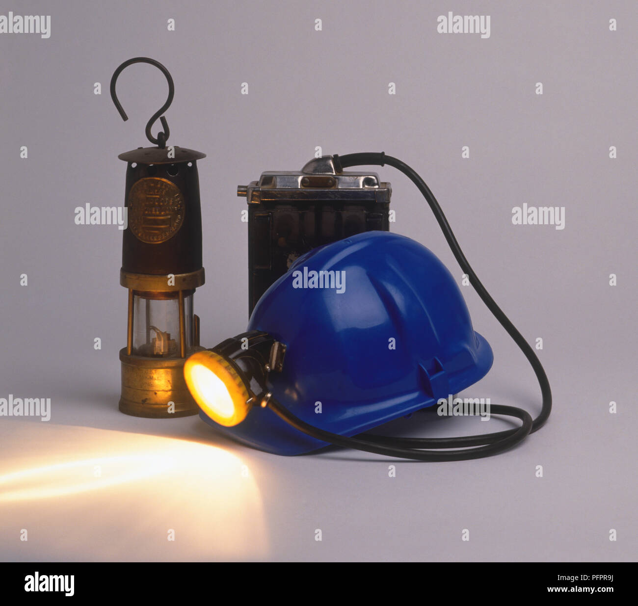 Davy lamp, and mining hardhat with headlight attached to battery, close-up Stock Photo