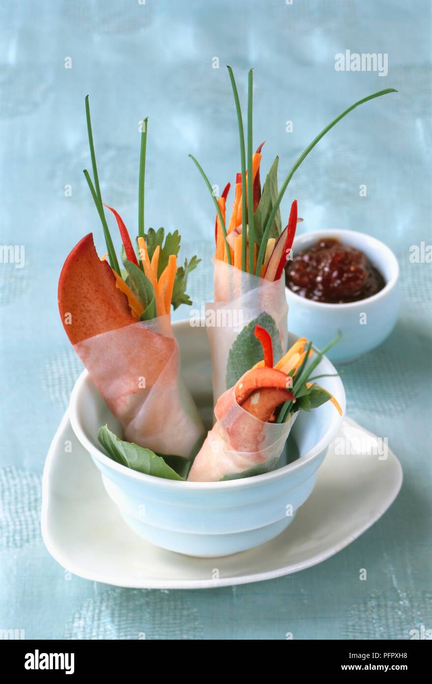 Crab and lobster claws and sliced vegetables wrapped in paper, with