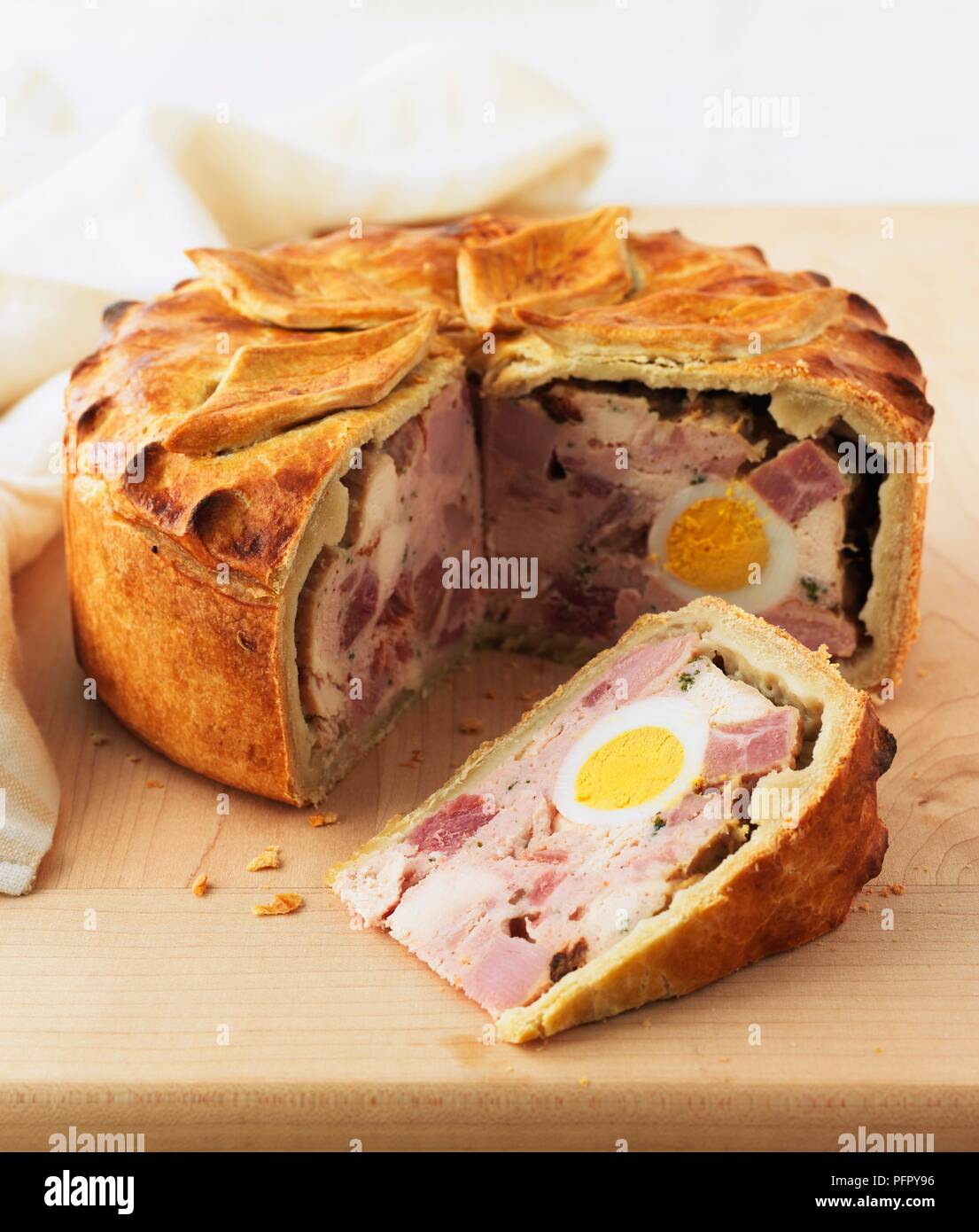 Cold chicken pie with boiled egg at centre, single slice cut away Stock