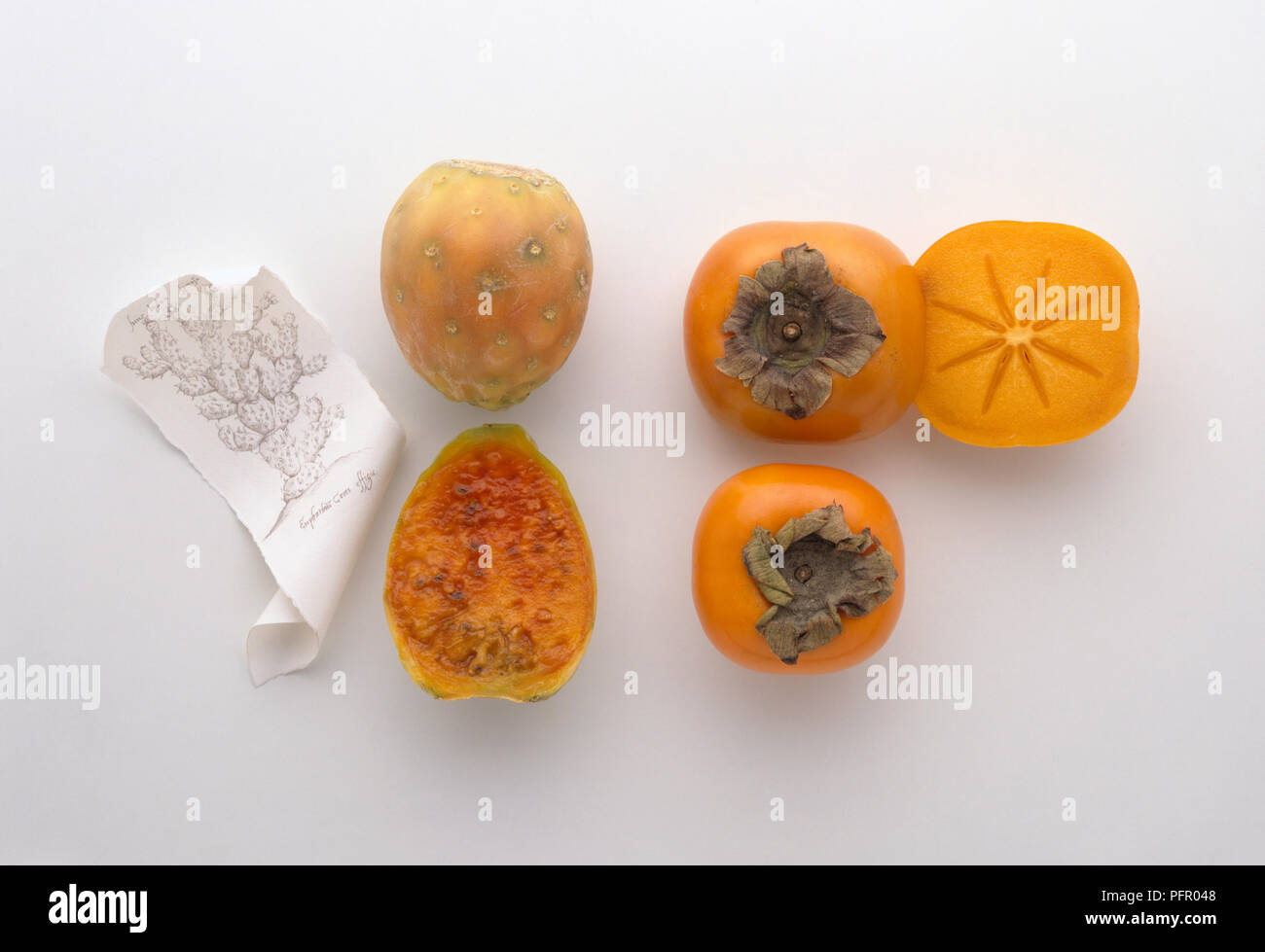 Whole and sliced Fuyu persimmon and prickly pear fruits Stock Photo