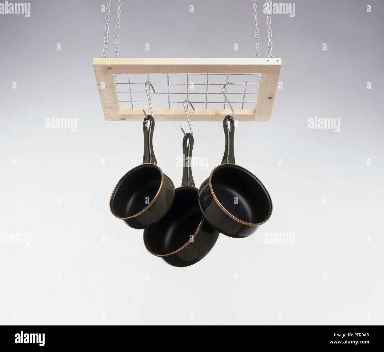 Saucepans hanging by hooks from rack Stock Photo Alamy