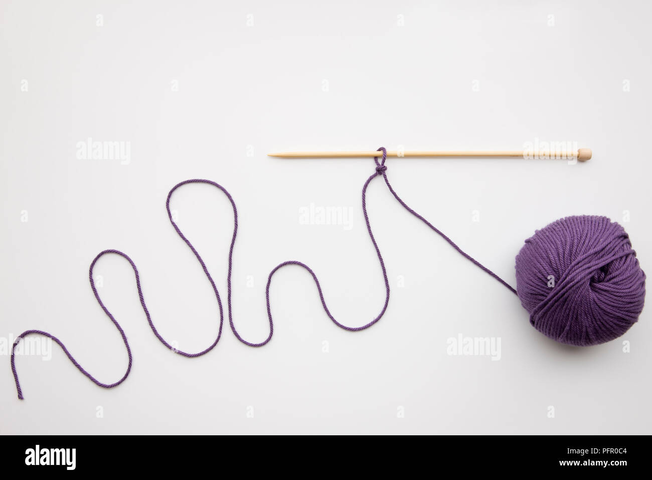 Slip knot on knitting needle and ball of purple wool Stock Photo Alamy