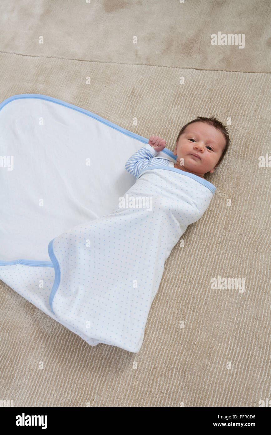 Baby boy being wrapped up in blanket Stock Photo