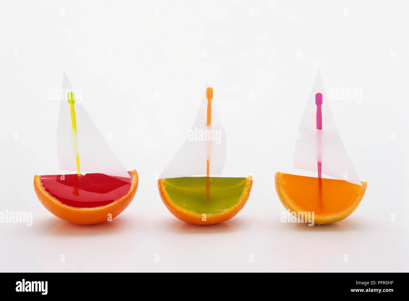 Strawberry, lime, and orange jelly boats with paper sails made from