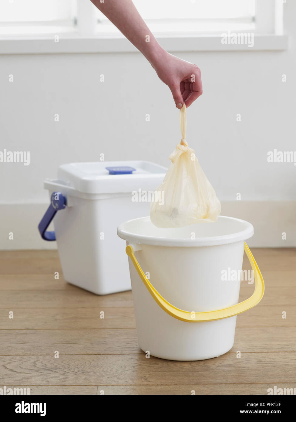 Nappy inside plastic bag being put in a bin Stock Photo Alamy