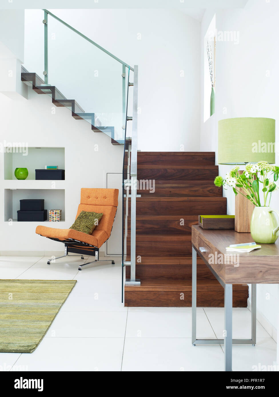 Openplan entrance hall with wooden staircase, side table and chair in