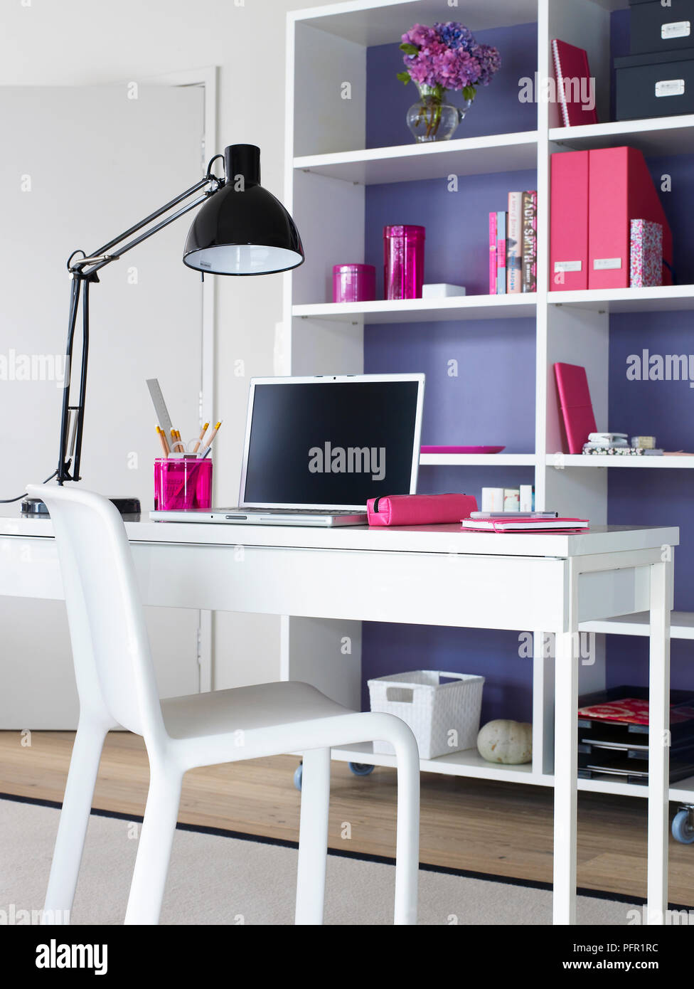 Home Office With Laptop Angle Poise Lamp And Stationary On Desk And White Shelves On Purple Wall Stock Photo Alamy