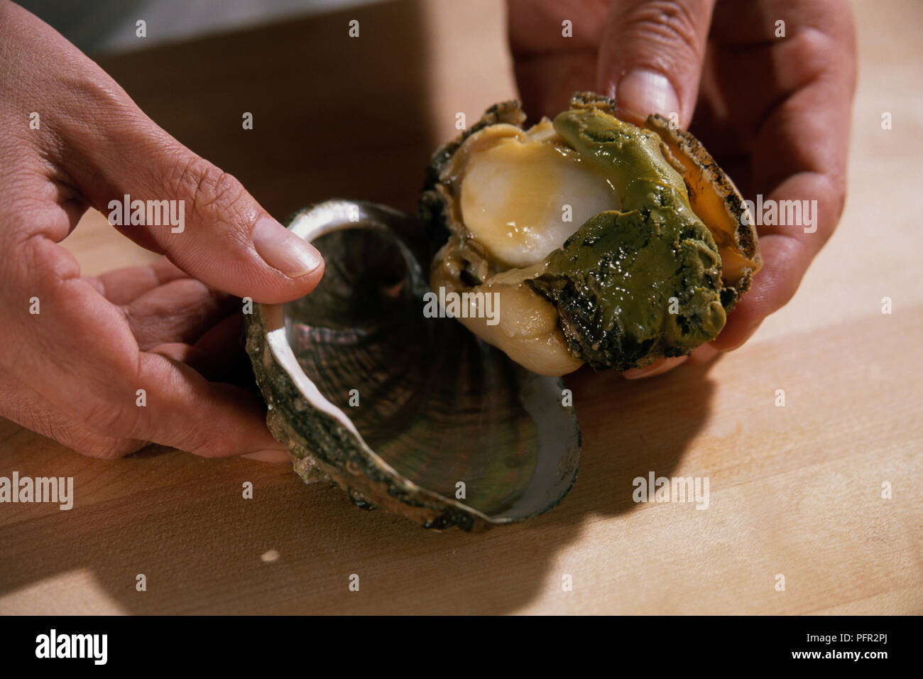Chef opening fresh abalone shell, close-up Stock Photo - Alamy