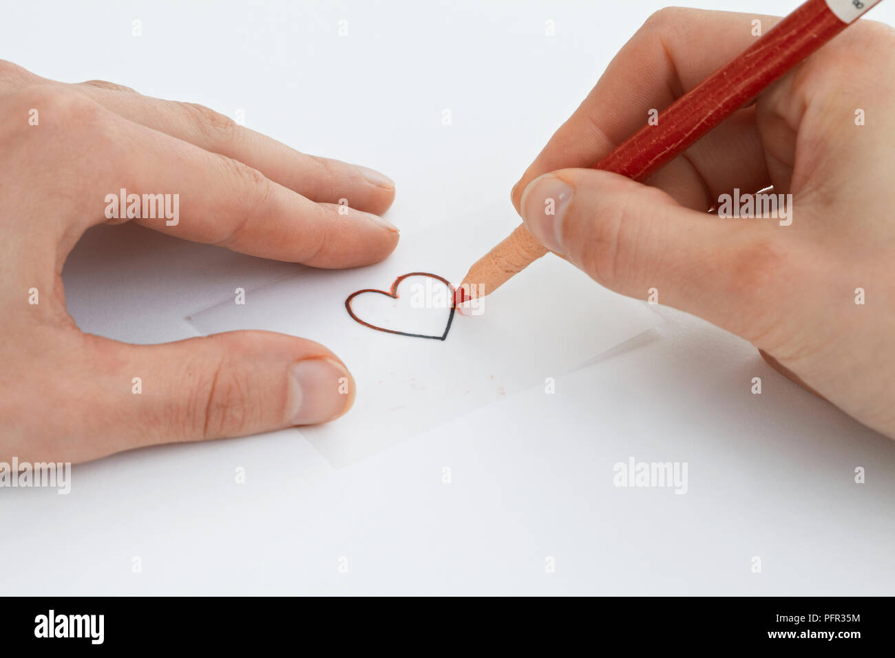 Drawing a glass painting design on a piece of tracing paper using a chinagraph pencil (heart shape) Stock Photo