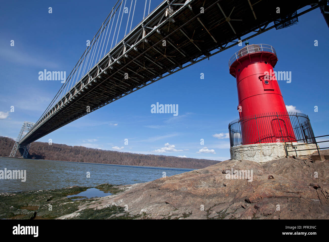 USA, New York, New York City, Jeffrey's Hook Light or Little Red Lighthouse below George Washington Bridge on Hudson River with blue sky above Stock Photo