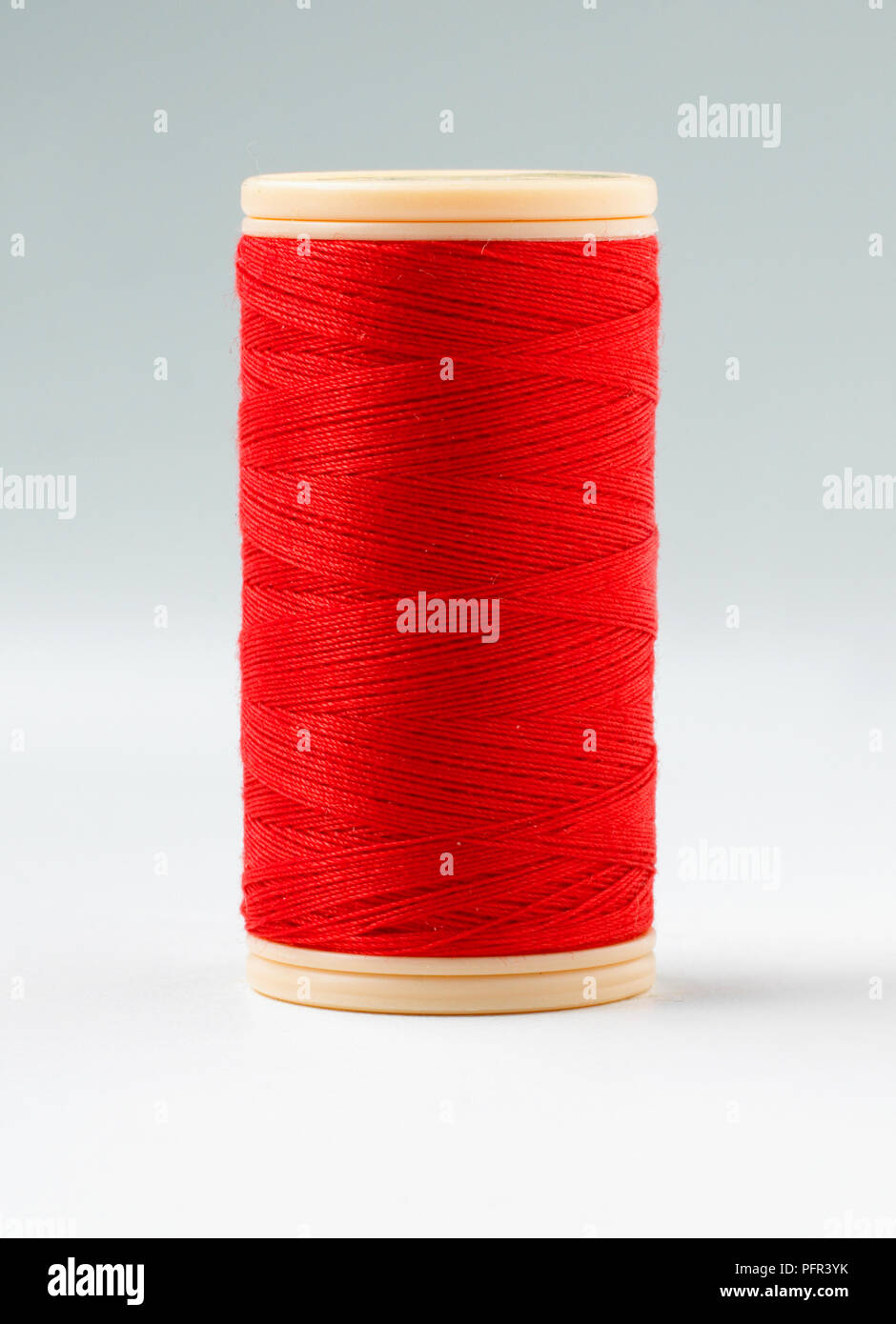 Reel of red cotton sewing thread Stock Photo