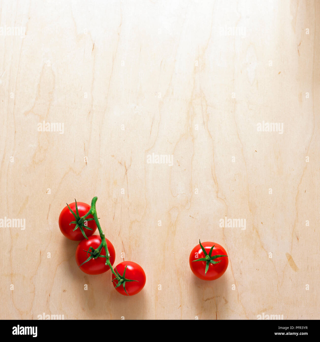 Vine tomatoes on wooden background Stock Photo