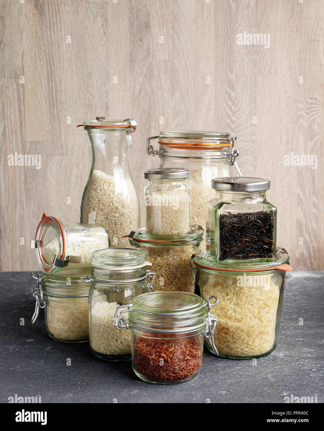Jars containing different types of rice, risotto rice, basmati rice, sushi rice, sticky rice, brown rice, wild rice, jasmine rice, pudding rice, red rice (camargue rice), long-grain rice Stock Photo