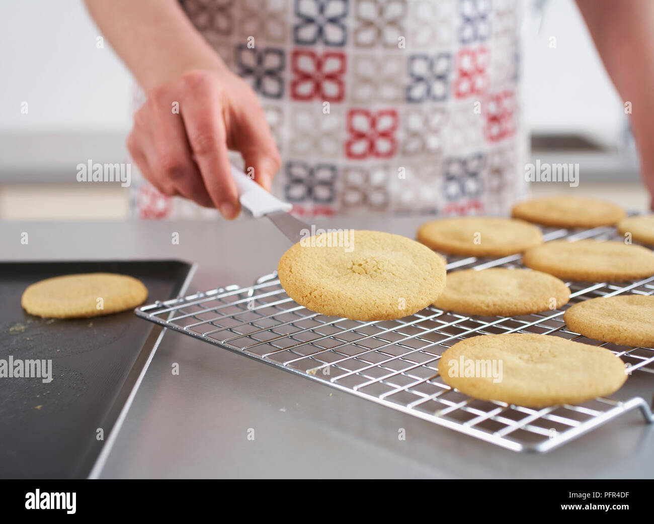 Placing round butter biscuits on cooling rack Stock Photo Alamy