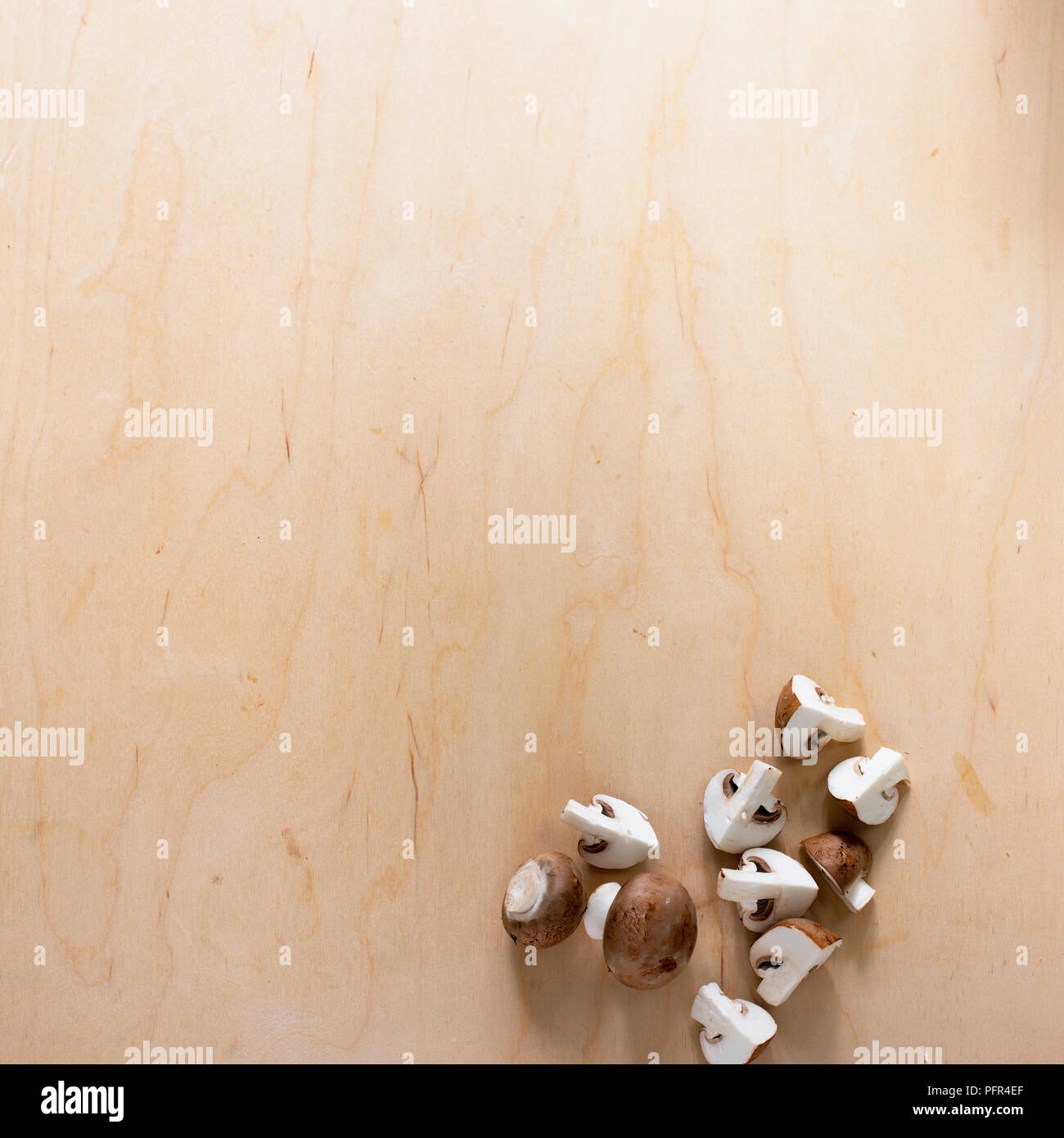 Chestnut mushrooms whole and quartered, on wooden surface Stock Photo