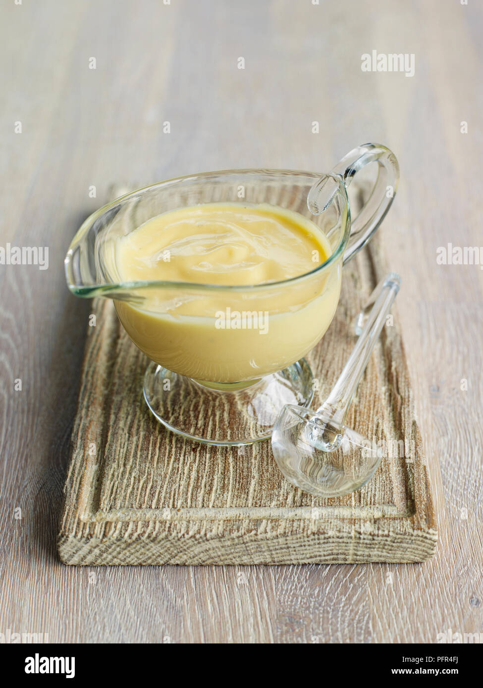 Mayonnaise sauce in glass jug, wood background Stock Photo