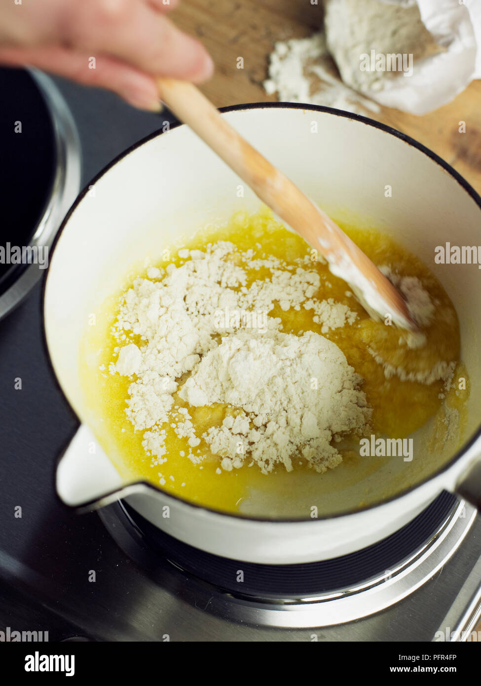 Mixing melted butter with flour (cooking bechamel sauce Stock Photo Alamy