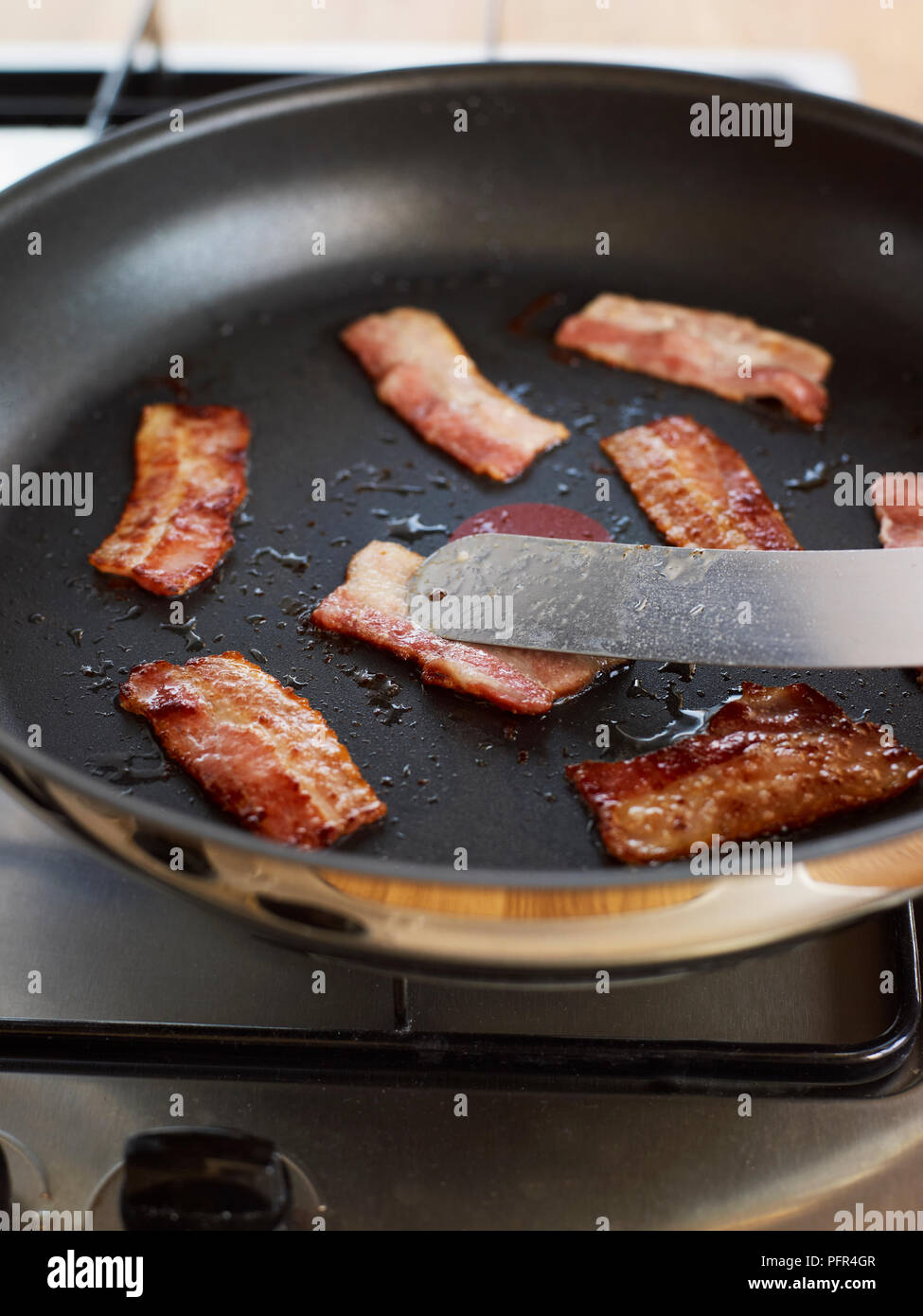 Frying bacon rashers Stock Photo