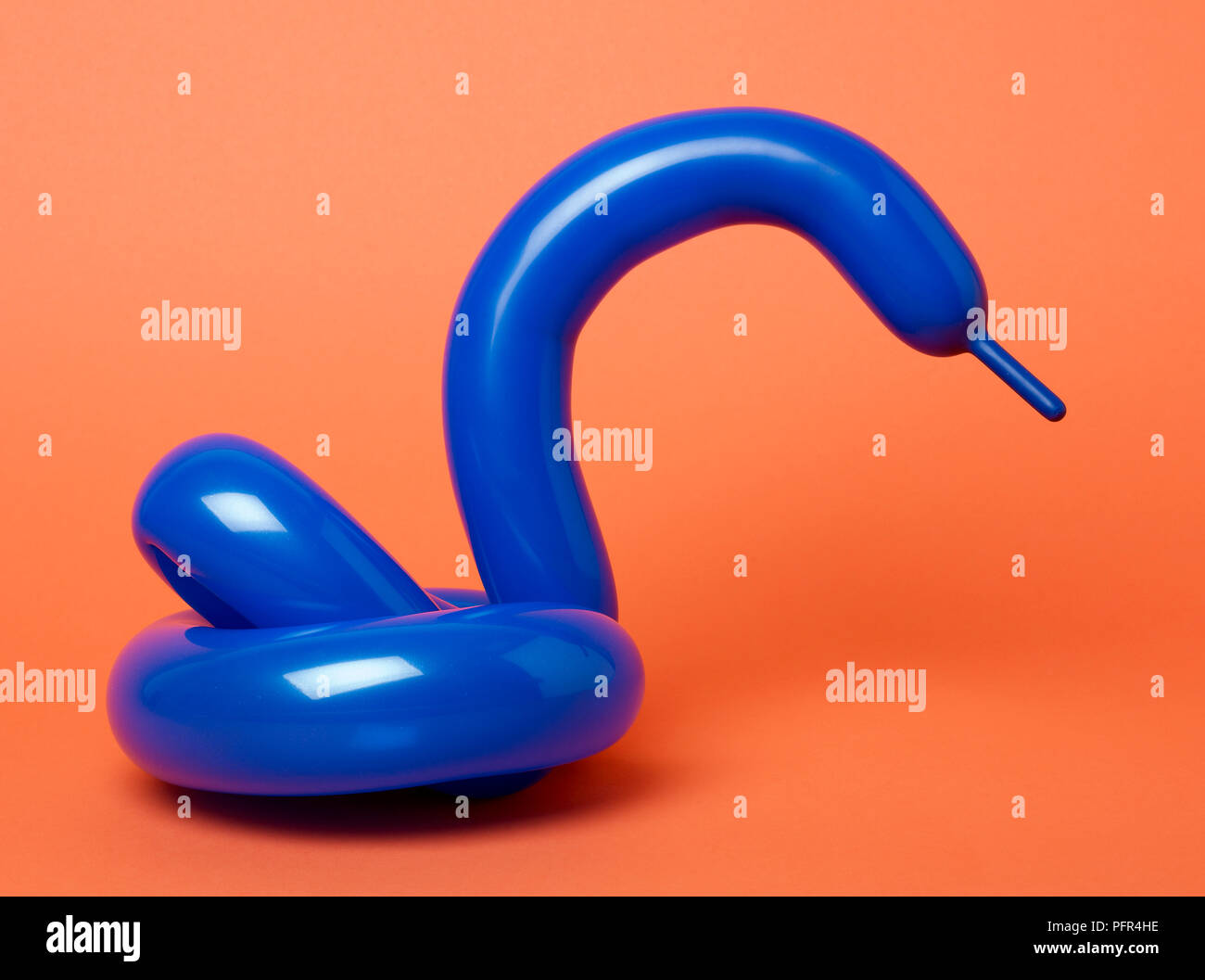 Blue balloon swan on red background Stock Photo