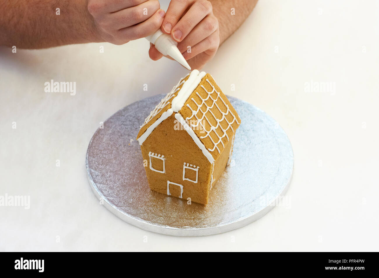 Piping icing on gingerbread house Stock Photo Alamy