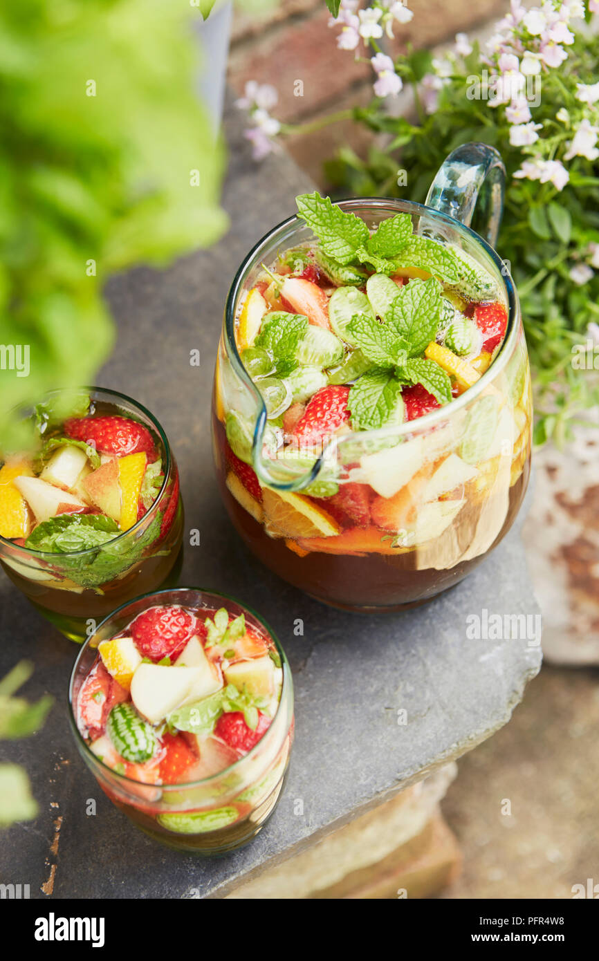 Jugs of pimms with strawberries, lemon and mint Stock Photo