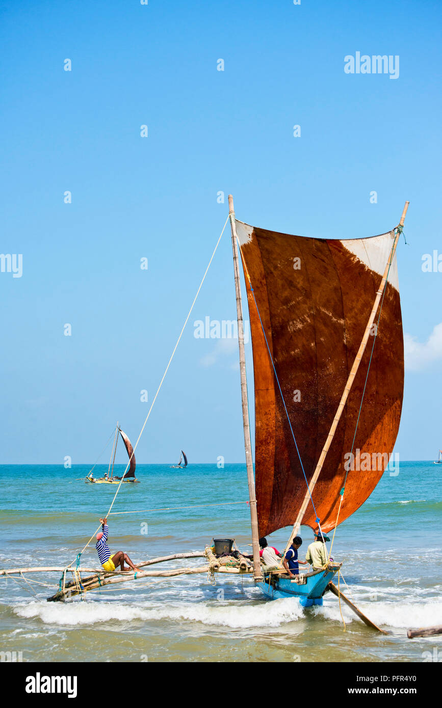 Sri Lanka, Western Province, Negombo Beach, fishermen in oruva boat Stock Photo