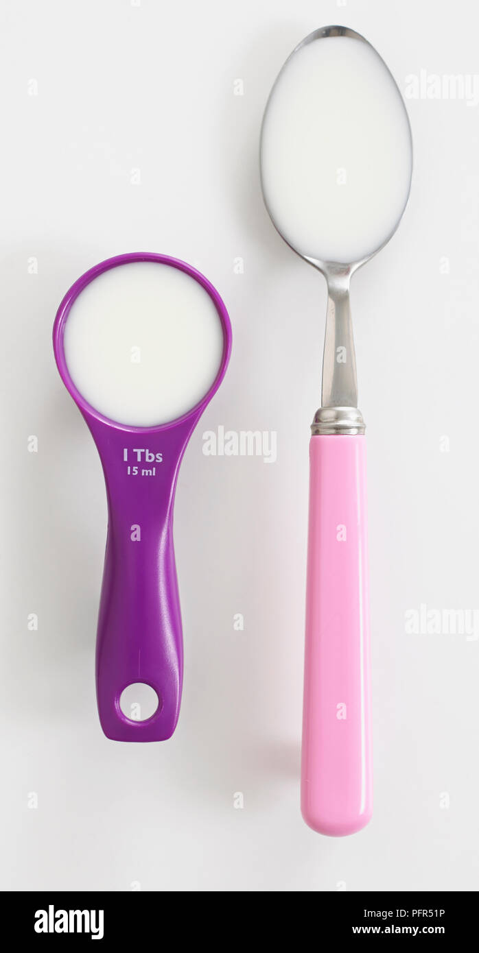 Spoons of milk, tablespoon and measuring spoon Stock Photo Alamy