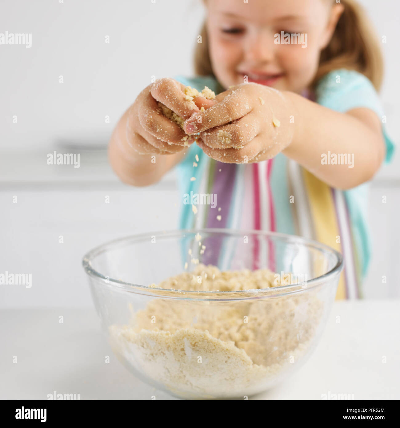 Girl making cookie dough mixture from butter and flour, 5 years Stock Photo