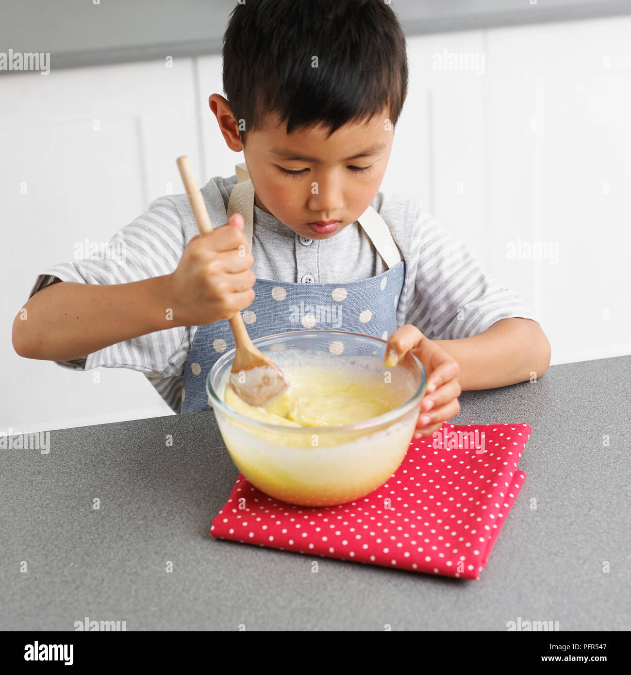 Making white chocolate truffles, Boy mixing white chocolate mixture, 4 years Stock Photo