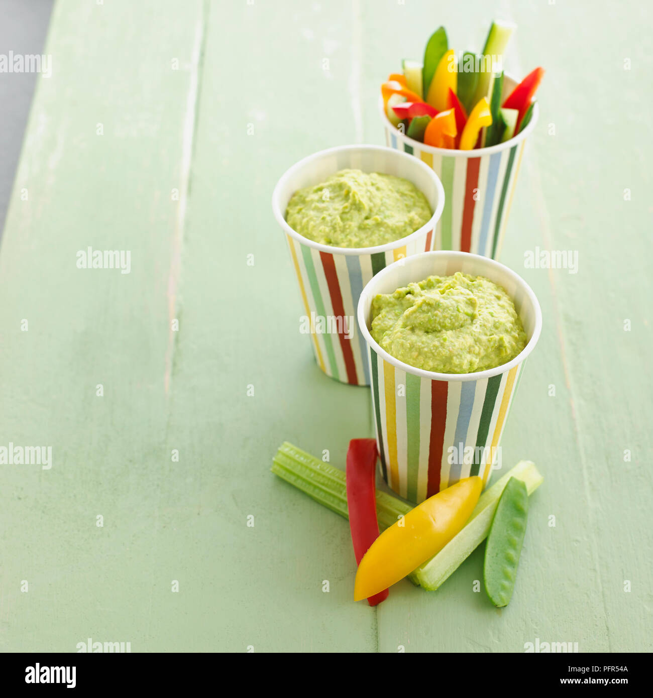 Cups of pea hummus and sticks of vegetable Stock Photo