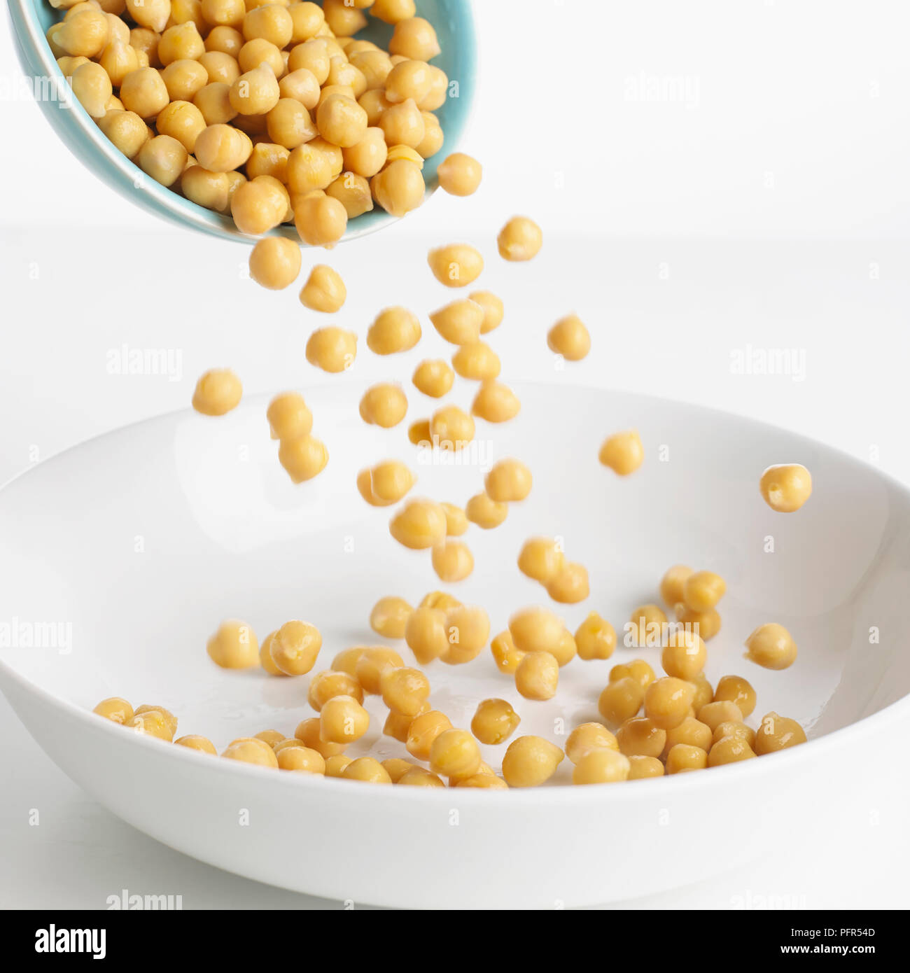 Pouring chickpeas into a bowl Stock Photo