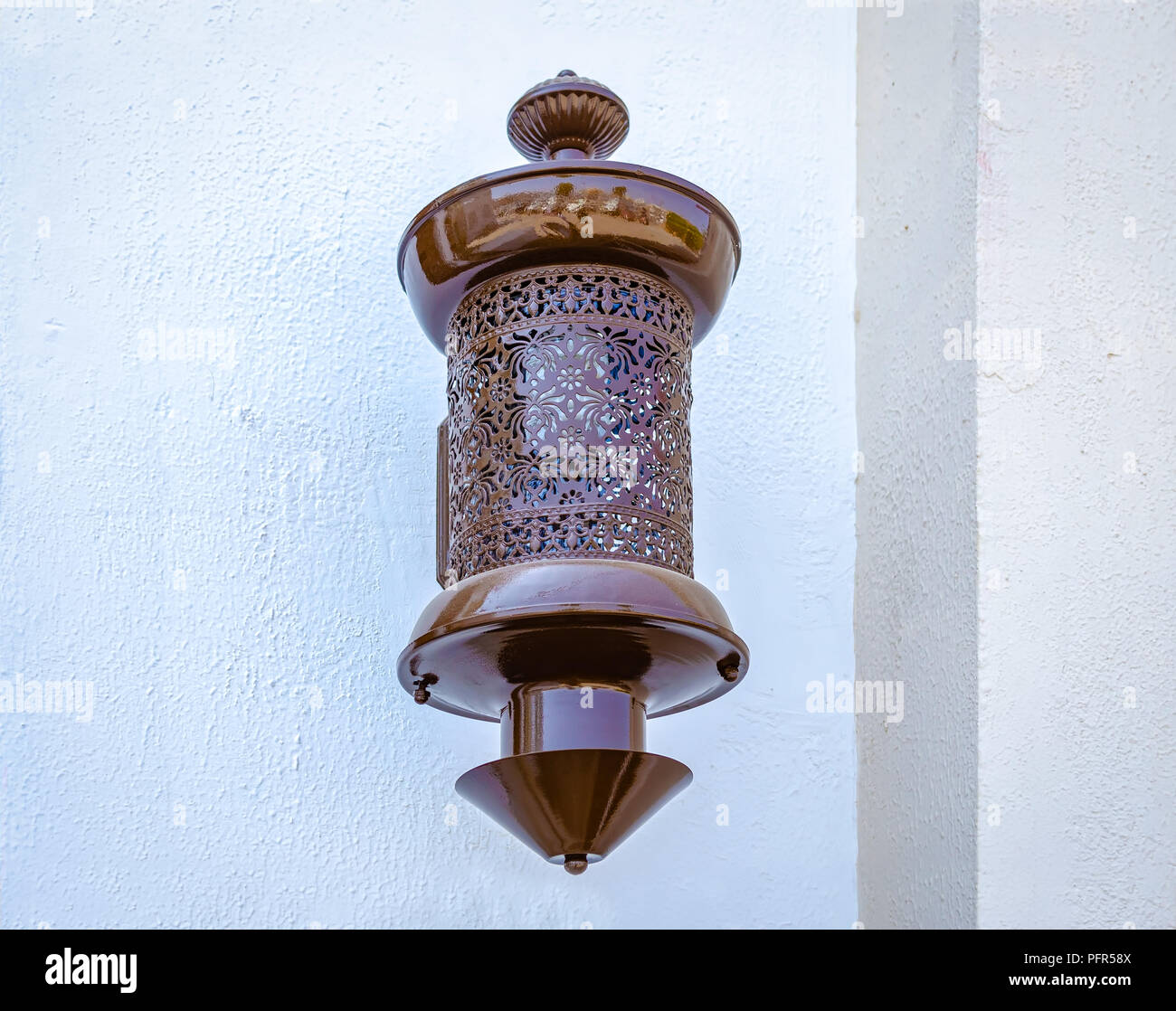 Brown, traditional electric lamp on the wall. From Muscat, Oman. Stock Photo