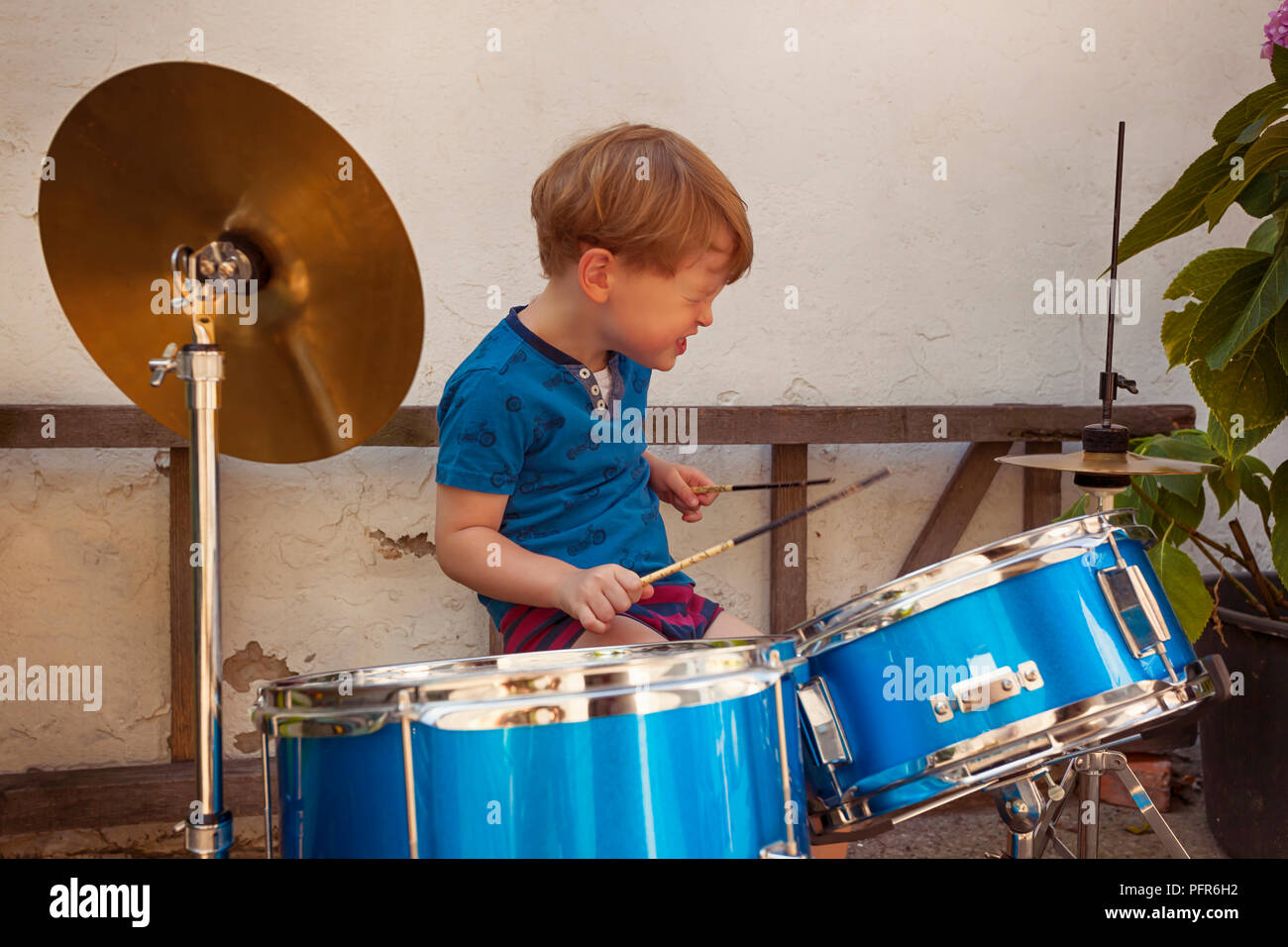 Amazing 3 year old Kid Drummer Playing with a rockstar attitude Stock Photo