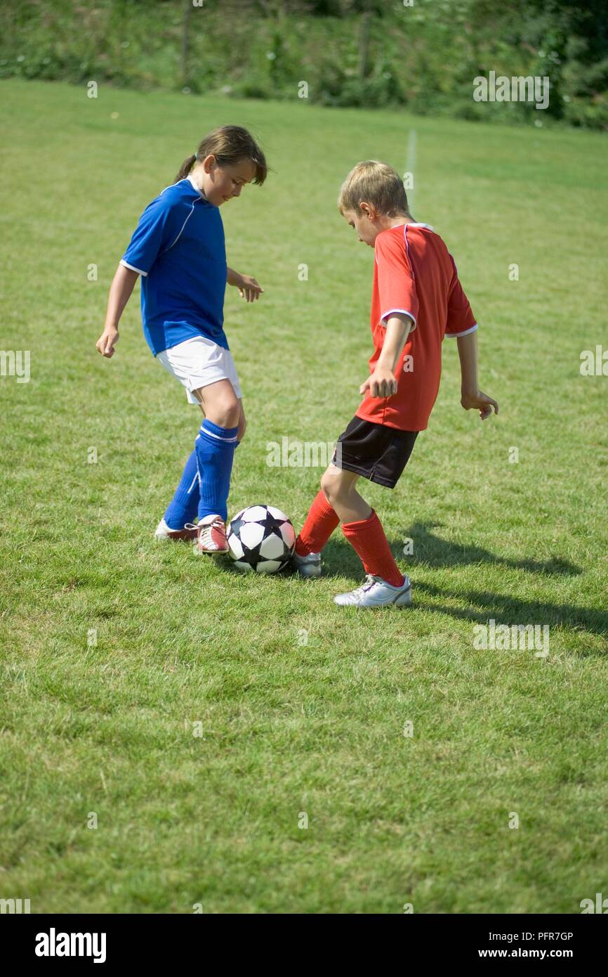 Boy and girl in football gear practising a block tackle Stock Photo - Alamy