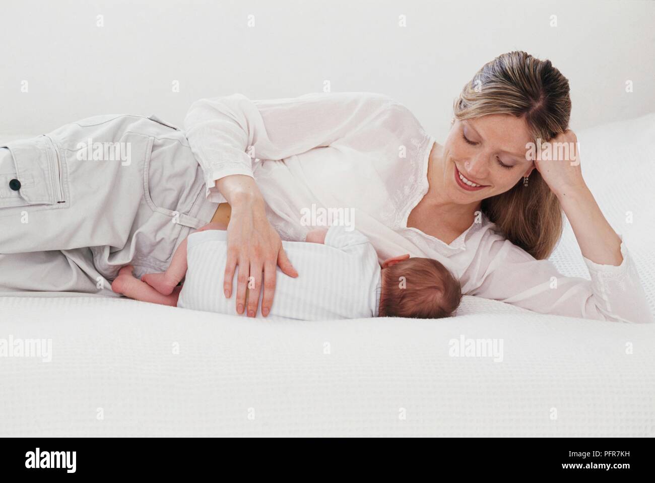 Mother breastfeeding baby looking down hires stock photography and