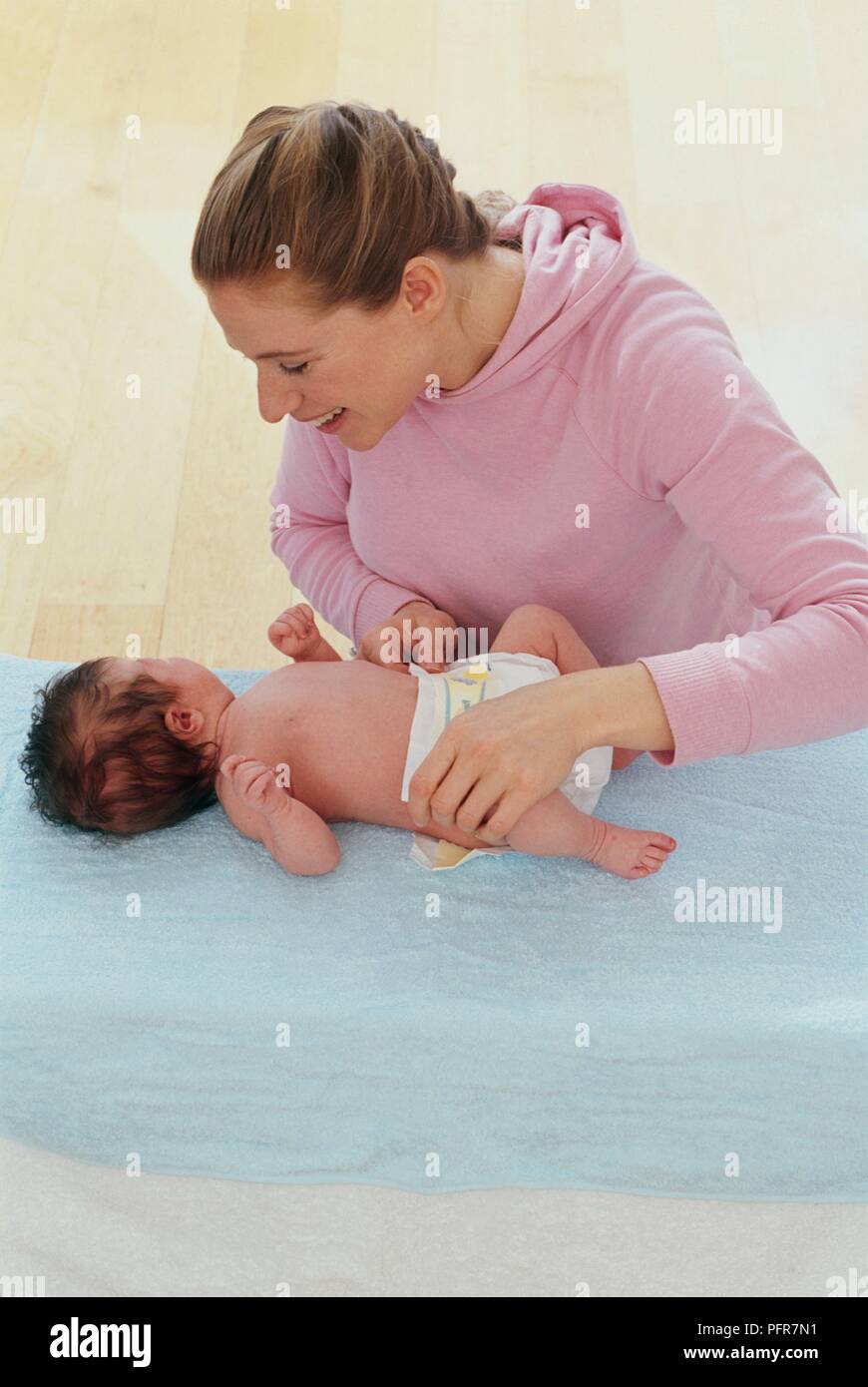 Mother putting nappy on month old baby boy Stock Photo Alamy