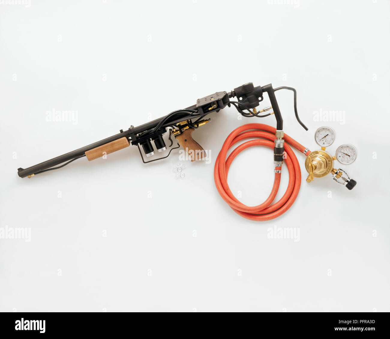Special effects gun designed for use in film with hose and compressed air pump providing power for the trigger Stock Photo