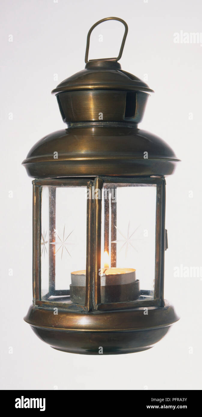 Small candle in old fashioned brass lantern Stock Photo