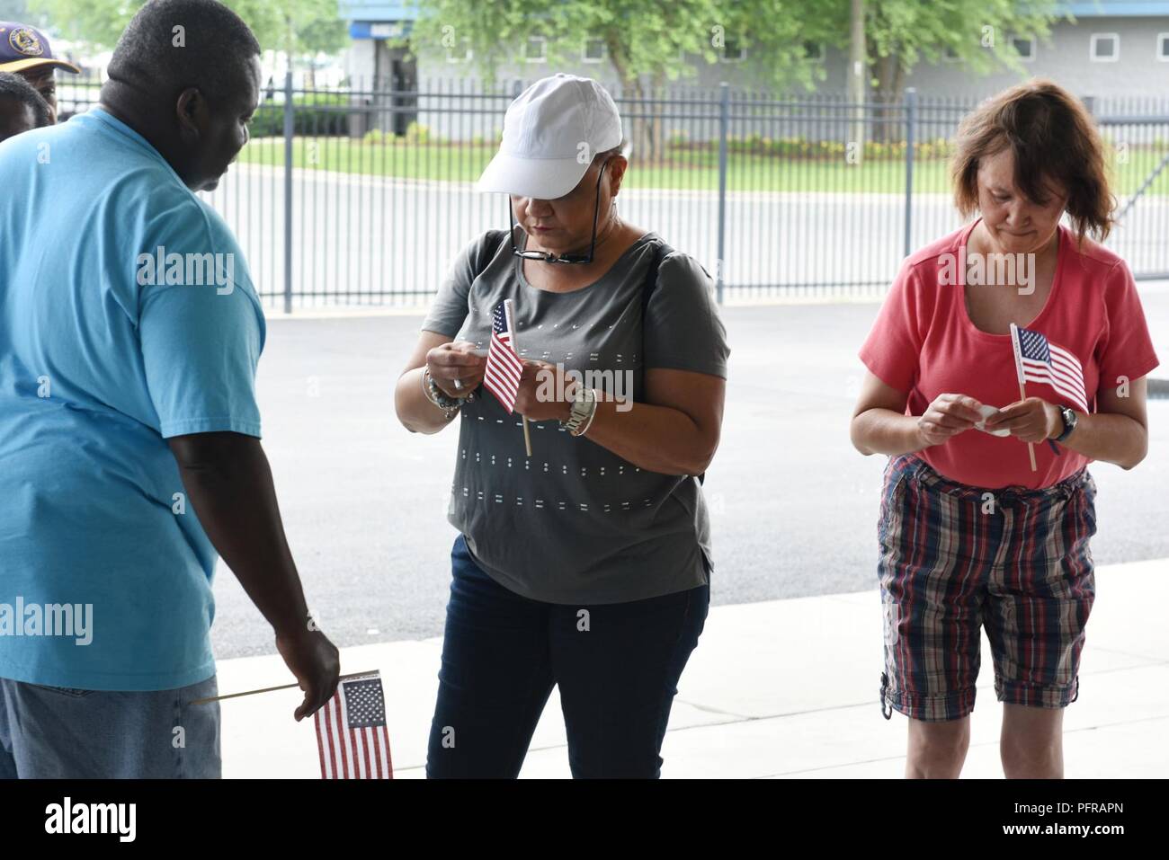 Addie Carmon (center), coordinator and owner of Evans Group Home in Greenville, N.C., assists some of her residents with stickers and flags at the Z-Max Pavilion, Charlotte N.C., during the annual Special Olympics Day at the Races, May 24, 2018. The Special Olympics Day at the Races is an annual celebration held at the Lowes Motor Speedway and is put on by Vangie Boswell and fourteen sponsors including the North Carolina Air National Guard (NCANG). Members of the NCANG help set-up the event and pass out mementos while mingling with State Special Olympians and their families. Stock Photo