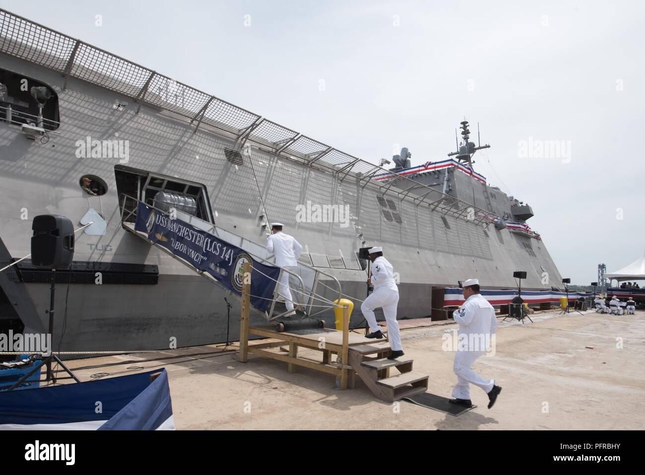 NH (May 26, 2018)  The crew of the Independence-variant littoral combat ship USS Manchester (LCS 14) board the ship after the ship's sponsor, Sen. Jeanne Shaheen (D-NH) gives the traditional order to 'man this ship and bring her to life.' Manchester is the 12th littoral combat ship to enter the fleet and the seventh of the Independence variant. The ship is named for the city of Manchester, New Hampshire and is assigned to Naval Surface Forces, U.S. Pacific Fleet. Stock Photo