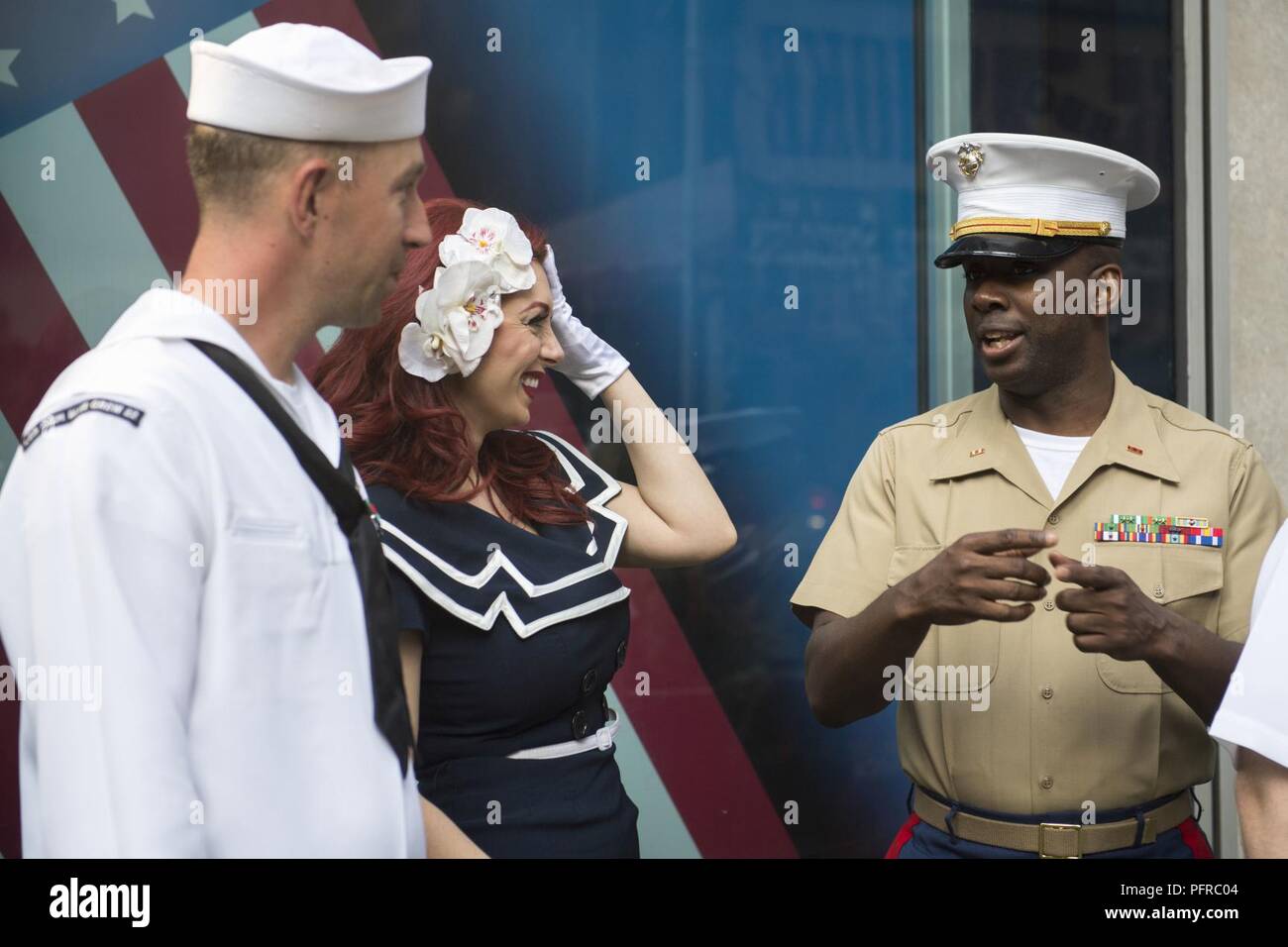 NEW YORK (May 25, 2018) Mineman 1st Class Keenan Rogers, of Minneapolis, Minnesota, assigned to the Littoral Combat Ship USS Little Rock (LCS 9), and Chief Warrant Officer Avin Hinton of Chesapeake City, Maryland, assigned to the Combat Logistics Regiment 25, speak with a member from the American Bombshells at the Fox and Friends Morning show BBQ competition during Fleet Week New York (FWNY). Now in its 30th year, FWNY is the city’s time-honored celebration of the sea services. It is an unparalleled opportunity for the citizens of New York and the surrounding tri-state area to meet Sailors, Ma Stock Photo