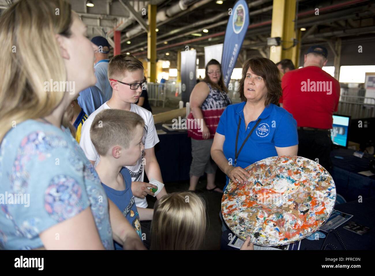 NEW YORK (May 26, 2018) Laura Busch, a natural resources program manager at U.S. Fleet Forces Command’s Fleet Environmental and Readiness Division, explains the shipboard waste process to reduce plastic waste aboard ships at the U.S. Navy’s “Stewards of the Sea: Defending Freedom, Protecting the Environment” exhibit during Fleet Week New York. The Navy employs every means available to mitigate the potential environmental effects of our activities without jeopardizing the safety of our Sailors or impacting our Navy readiness mission. Stock Photo