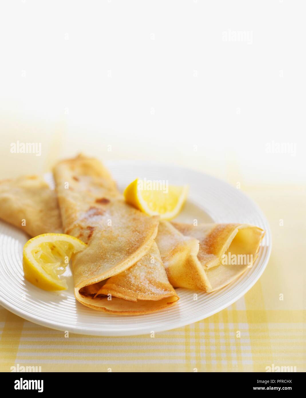 Pancakes on white plate with slices of lemon Stock Photo