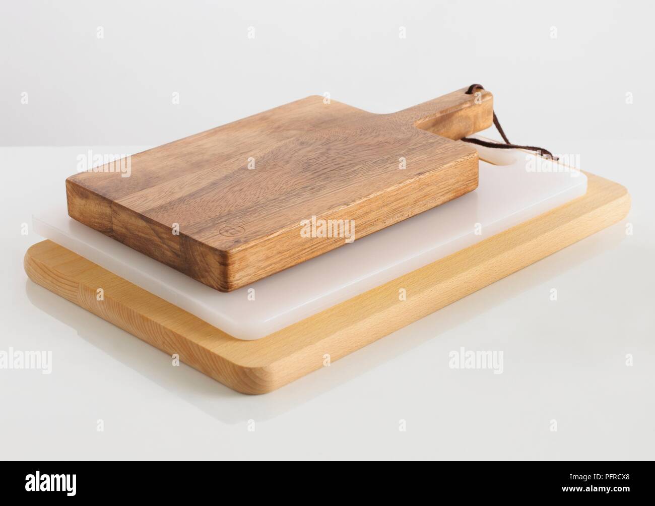 Three chopping boards in wood and plastic on top another Stock Photo