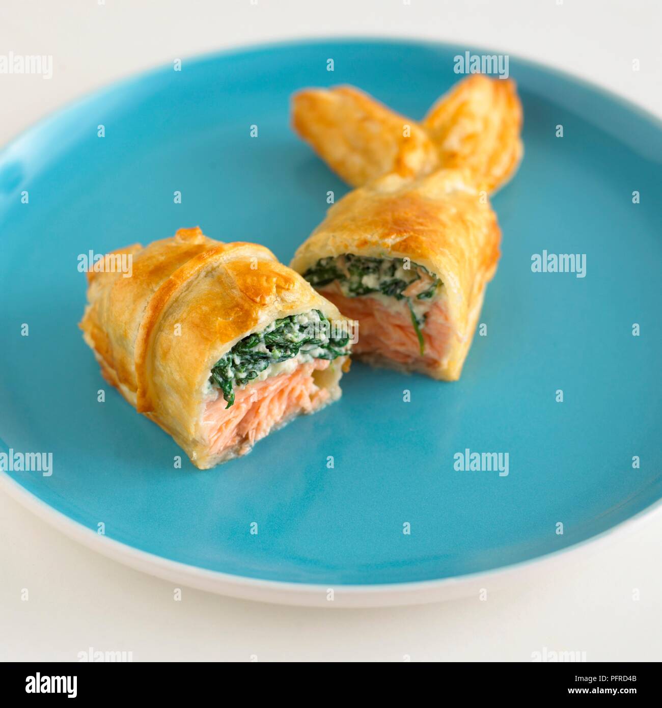 Fishshaped puff pastry cut in half showing spinach and salmon stuffing